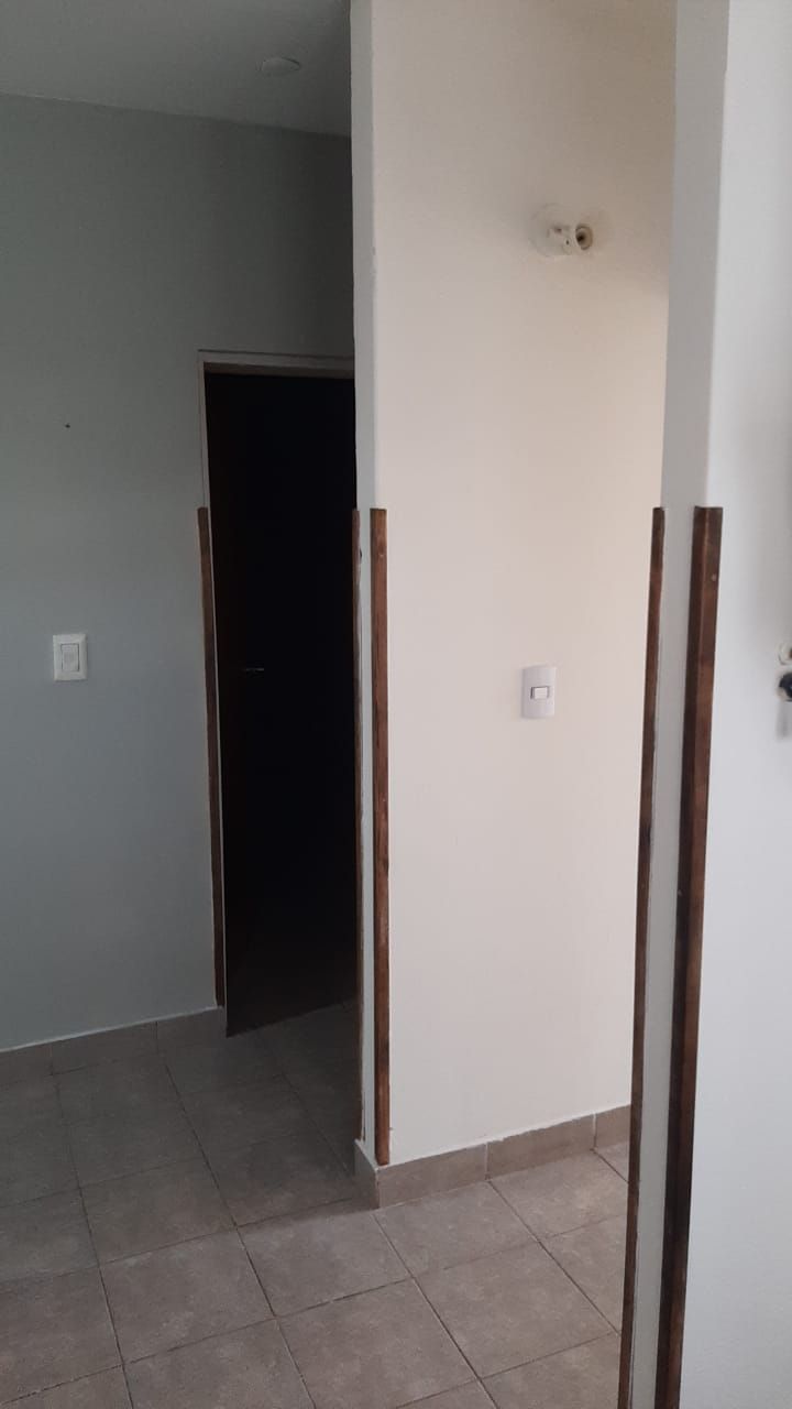 Pasillo con paredes blancas y zócalo de madera.