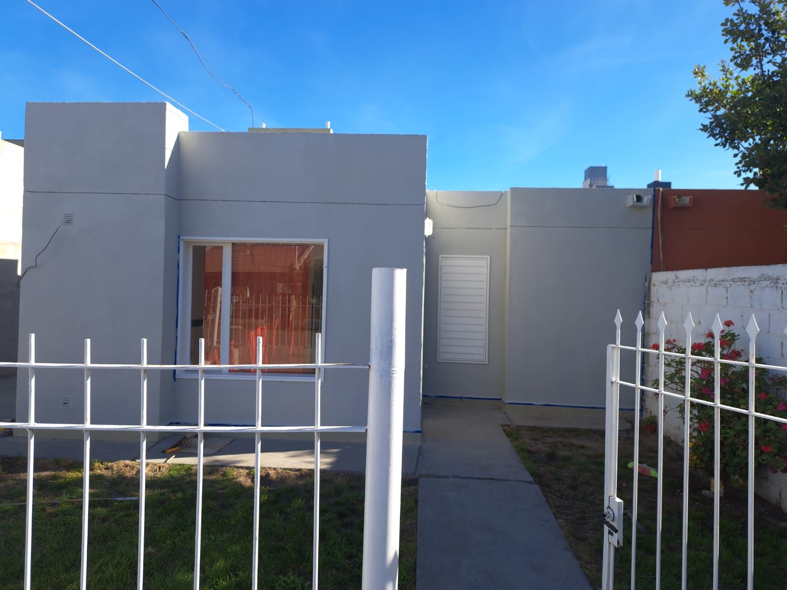 Frente del departamento con reja y vereda.