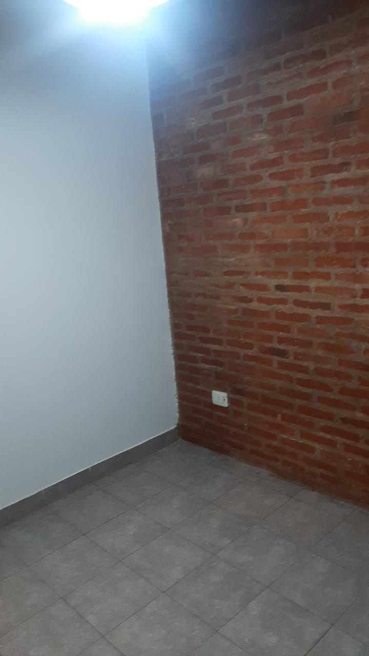 Ambiente con una pared de ladrillo visto y luz en el techo.